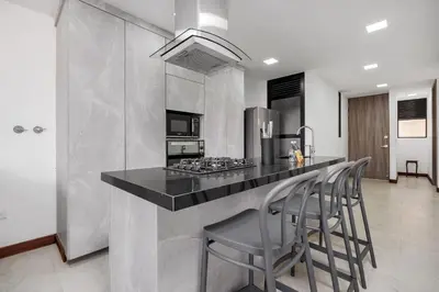 a kitchen with a counter with stools and a stove at Medellin-Cerca al Poblado-201 in Medellín