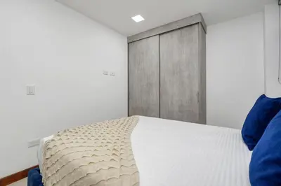 a bedroom with a bed with a wooden door at Medellin-Cerca al Poblado-201 in Medellín