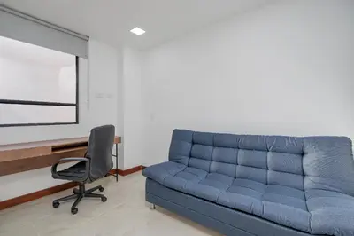 a blue couch in a room with a chair at MEDELLIN- Cerca al Poblado - 301 in Medellín