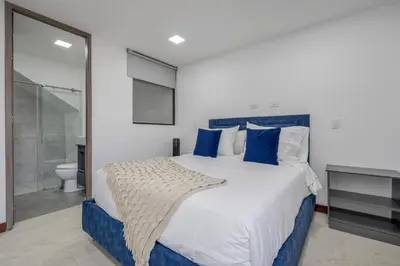 a bedroom with a blue and white bed and a bathroom at MEDELLIN- Cerca al Poblado-401 in Medellín