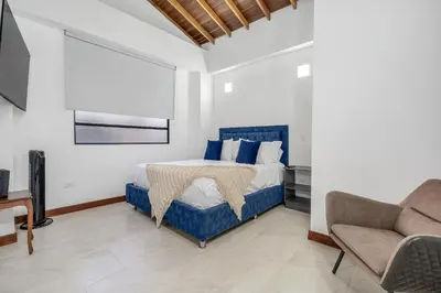 a bedroom with a bed and a couch and a chair at MEDELLIN- Cerca al Poblado-401 in Medellín