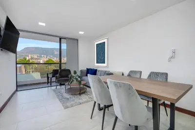 a living room with a wooden table and chairs at MEDELLIN- Cerca al Poblado-401 in Medellín