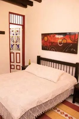 a bedroom with a bed and a painting on the wall at El Despertar Hotel in Jericó