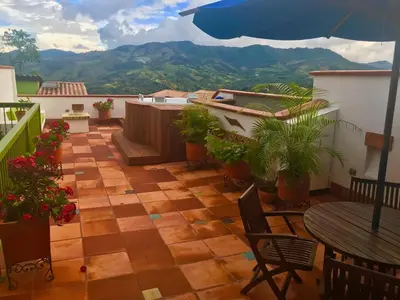 a patio with an umbrella and a table and chairs at El Despertar Hotel in Jericó