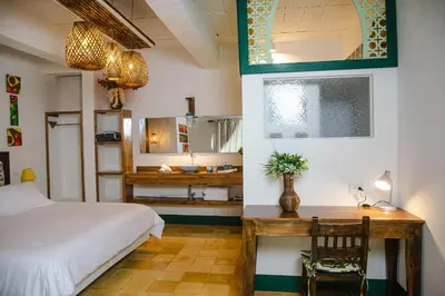 a bedroom with a bed and a desk and a bathroom at El Despertar Hotel in Jericó