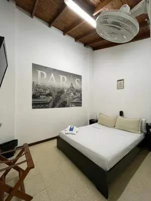 a bedroom with a bed and a poster on the wall at Hostal Lleras Calle 8 in Medellín