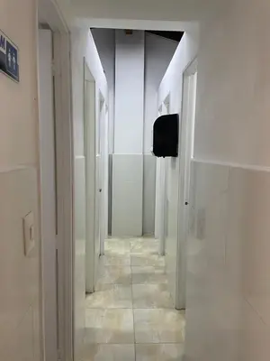 a hallway with white walls and a hallway with white doors at Hostal Lleras Calle 8 in Medellín