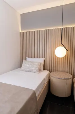 a small bedroom with a bed and a lamp at Hotel Zona A in Medellín