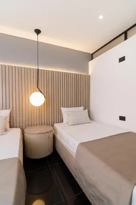 a bedroom with two beds and a light fixture at Hotel Zona A in Medellín