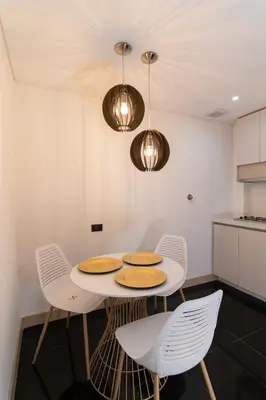 a kitchen with a table and chairs and lights at Hotel Zona A in Medellín