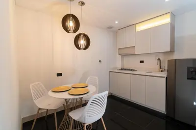 a kitchen with a table and chairs in a kitchen at Hotel Zona A in Medellín