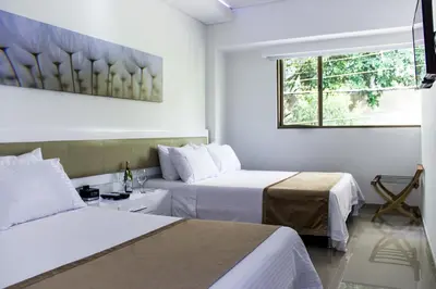 a hotel room with two beds and a window at Hotel Zona A in Medellín