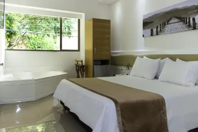 a bedroom with a bed and a bath tub and a window at Hotel Zona A in Medellín