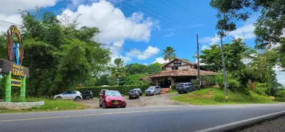 a street with cars parked in front of a house at Hotel Parador del Gitano in Doradal