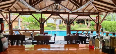 a restaurant with a table and chairs and a pool at Hotel Parador del Gitano in Doradal