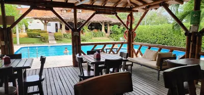a restaurant with tables and chairs and a swimming pool at Hotel Parador del Gitano in Doradal