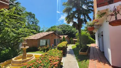 a house with a garden with a fountain and flowers at Hotel Parador del Gitano in Doradal