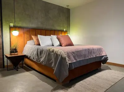 a bedroom with a large bed with a wooden headboard at Apto BBC With Jacuzzi In Heart Of Provenza in Medellín