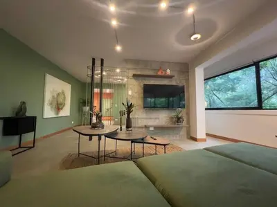 a bedroom with a bed and a table and a tv at Apto BBC With Jacuzzi In Heart Of Provenza in Medellín
