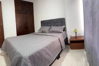 a bedroom with a bed and a table with a night stand at Apartamento en Bello Medellín in Bello