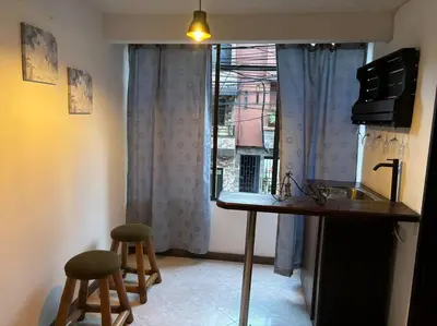 a kitchen with a counter and two stools in front of a window at Apartamento en Bello Medellín in Bello