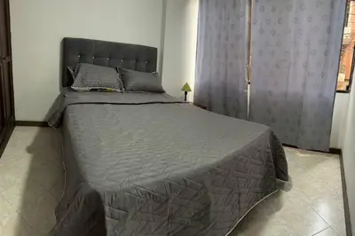 a bedroom with a large bed with a gray comforter at Apartamento en Bello Medellín in Bello