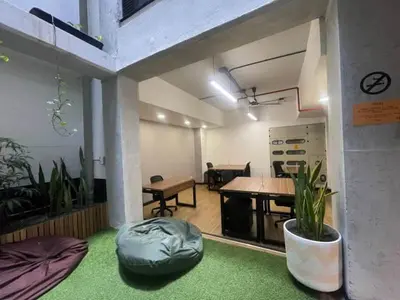 a large room with a table and a room with plants at Dormitorios en Medellín con áreas comunes, Coworking - Be Together by Roots Rentals TOG HAB in Medellín