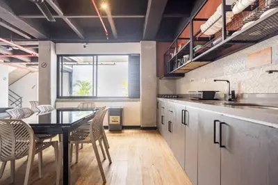 a kitchen with a table and chairs in a room at Dormitorios en Medellín con áreas comunes, Coworking - Be Together by Roots Rentals TOG HAB in Medellín