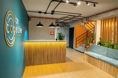 an office lobby with a bar with a colgate sign on the wall at Dormitorios en Medellín con áreas comunes, Coworking - Be Together by Roots Rentals TOG HAB in Medellín