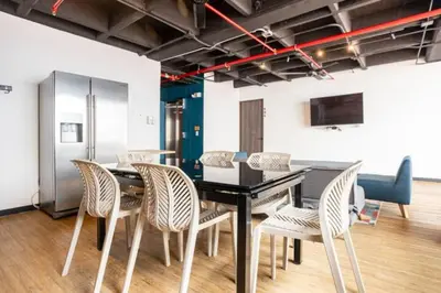 a dining room with a black table and chairs at Dormitorios en Medellín con áreas comunes, Coworking - Be Together by Roots Rentals TOG HAB in Medellín
