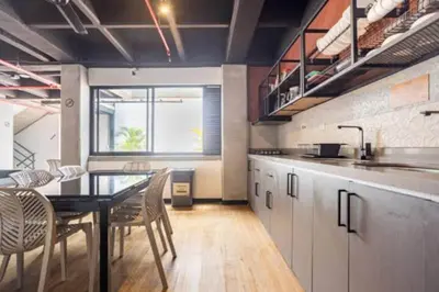 a kitchen with a table and chairs in a room at Dormitorios en Medellín con áreas comunes, Coworking - Be Together by Roots Rentals TOG HAB in Medellín