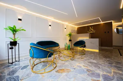 a salon with blue chairs and a table in a room at Naiot Hotel Boutique in Medellín