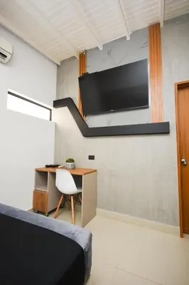 a room with a desk and a tv on a wall at Naiot Hotel Boutique in Medellín