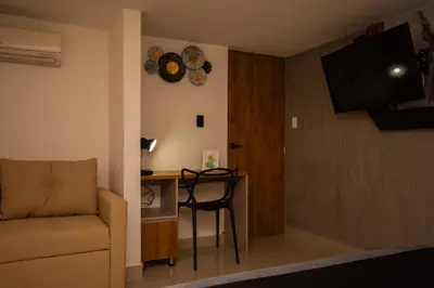 a living room with a desk and a couch and a chair at Naiot Hotel Boutique in Medellín