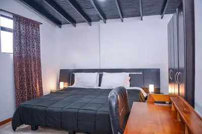 a bedroom with a large bed with a wooden table at Apartment El Jeffe Medellin in Medellín