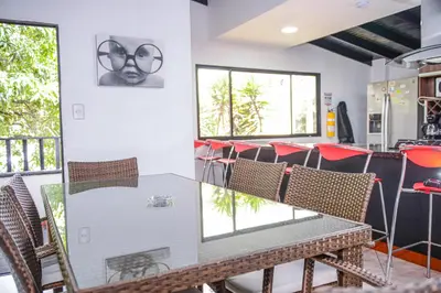 a table and chairs in a room with windows at Apartment El Jeffe Medellin in Medellín