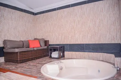 a bath tub in a room with a couch at Apartment El Jeffe Medellin in Medellín