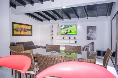 a room with a table and chairs and a tv at Apartment El Jeffe Medellin in Medellín