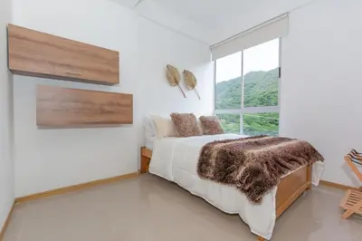 a bedroom with a bed and a large window at Apartamento Vacacional San Jeronimo Paraíso Bali in San Jerónimo