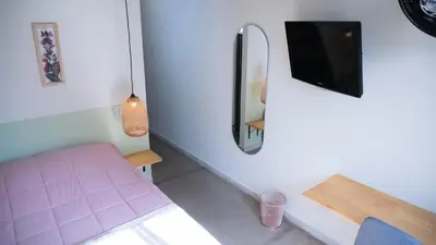 a bedroom with a pink bed and a tv on a wall at Selva House in Medellín