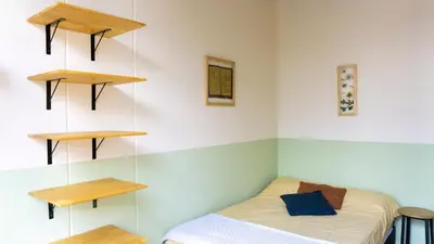 a room with a bed and shelves on the wall at Selva House in Medellín