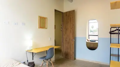 a room with a desk and a bed and a door at Selva House in Medellín
