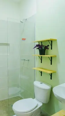 a bathroom with a toilet and a glass shower at Selva House in Medellín