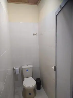a white bathroom with a toilet and a shower at Casa Rio y Montaña in Honda