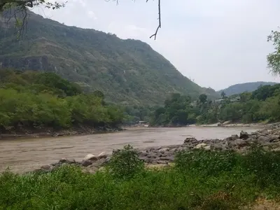 a river with rocks and trees and a mountain at Casa Rio y Montaña in Honda