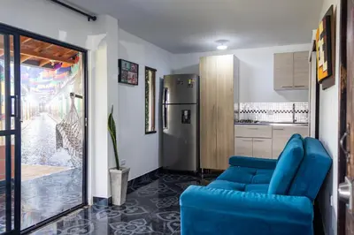 a living room with a blue couch and a kitchen at Mayka cabañas con JACUZZI in Guatapé