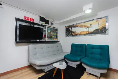 a living room with a couch and a flat screen tv at Hotel Lares 70 Laureles in Medellín