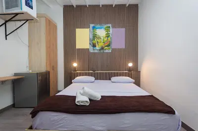 a bedroom with a bed with two towels on it at Hotel Lares 70 Laureles in Medellín