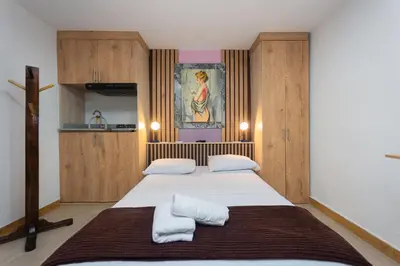 a bedroom with two beds and a painting on the wall at Hotel Lares 70 Laureles in Medellín