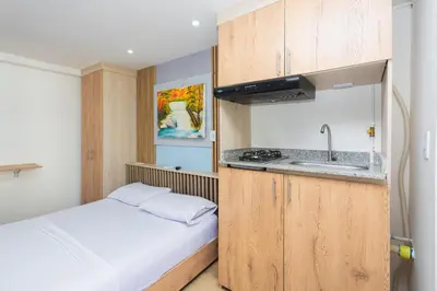 a small kitchen with a bed and a sink at Hotel Lares 70 Laureles in Medellín